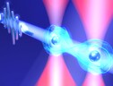 Rappresentazione artistica di due atomi di rubidio raffreddati quasi fino allo zero assoluto e manipolati con un impulso di luce laser di 10 picosecondi (fonte: Dr. Takafumi Tomita/IMS) (ANSA)