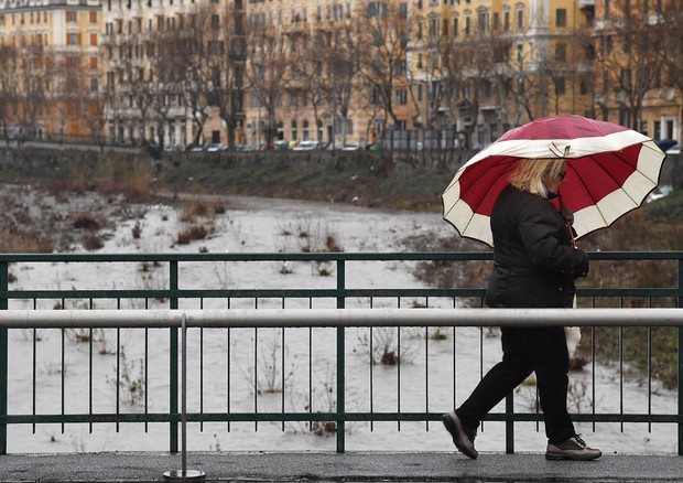 Una donna fotografata sotto la pioggia © ANSA
