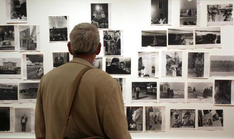 Un uomo guarda alcune fotografie di Robert Frank © AP