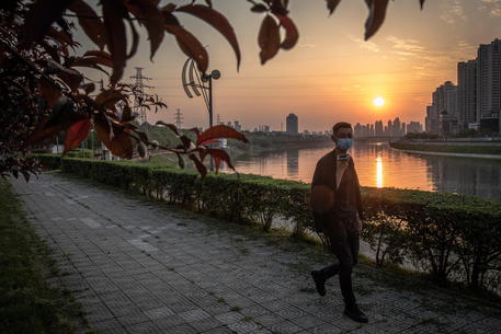 Un uomo cammina lungo la riva del fiume Hanshui, a Wuhan © EPA