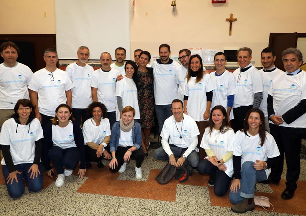 La conduttrice televisiva Geppi Cucciari posa con alcuni dei volontari impegnati nella Giornata del  volontariato proposta da Snam © ANSA