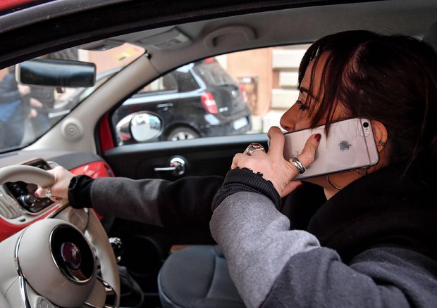 Una donna parla al cellulare mentre guida un'automobile © ANSA 
