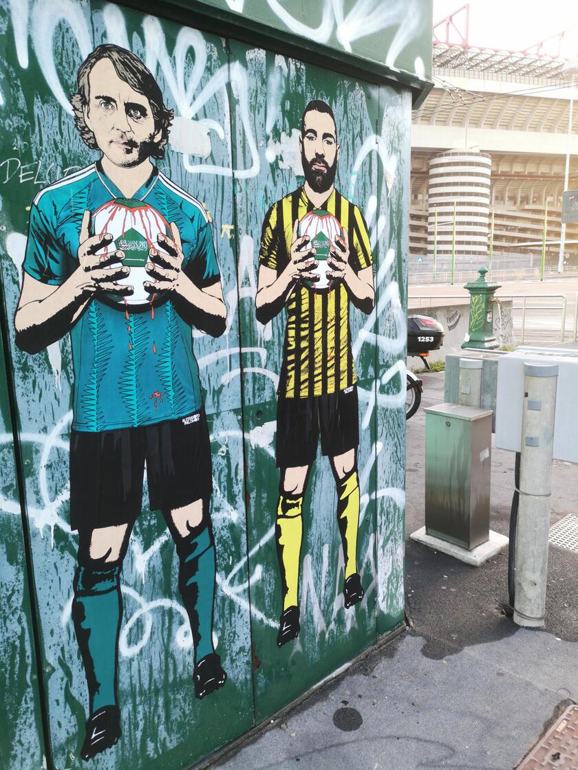 Mancini e Bin Salman con un pallone insanguinato: il murales a San Siro - RIPRODUZIONE RISERVATA
