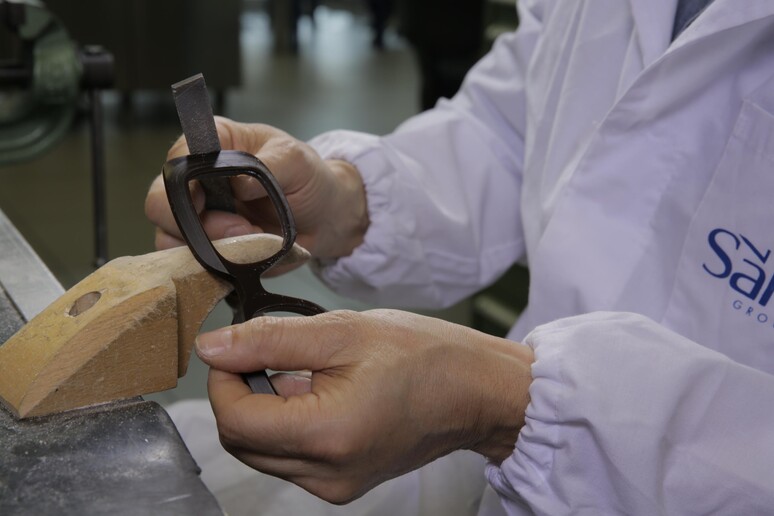 Un operaio al lavoro su un paio di occhiali in un laboratorio della Safilo in un 'immagine d 'archivio. - RIPRODUZIONE RISERVATA