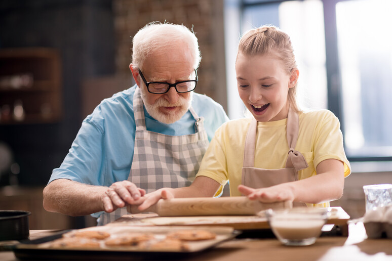 Nonno e nipote cucinano insieme foto iStock. - RIPRODUZIONE RISERVATA