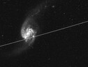 L’immagine di una galassia attraversata dalla scia luminosa di satelliti (fonte: Nasa/Esa Hubble/Kruk et al.) (ANSA)