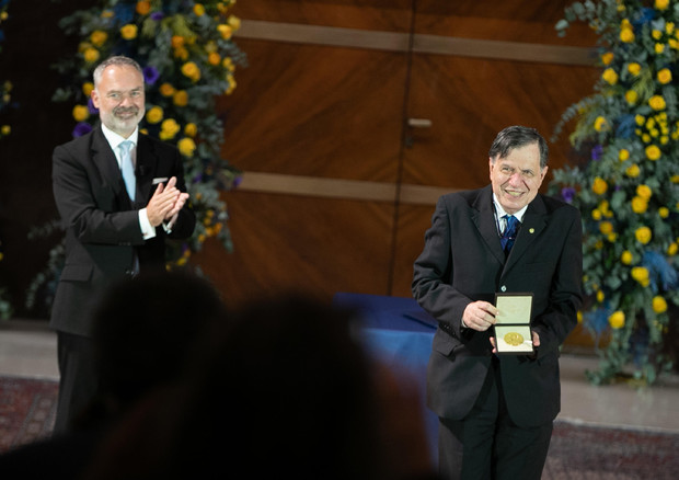 Giorgio Parisi mostra la medaglia Nobel nella cerimonia di premiazione all'Università Sapienza di Roma © ANSA