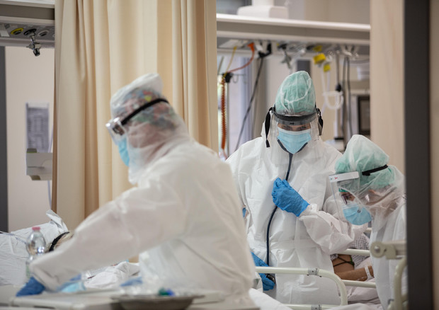 Operatori sanitari, che indossano tute protettive mediche e mascherine, al lavoro nella terapia intensiva dell'Ospedale Sant'Orsola di Bologna © ANSA