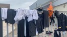Olbia, i lavoratori di Air Italy appendono le divise alla recinzione dell'aeroporto e danno fuoco a una sciarpa(ANSA)