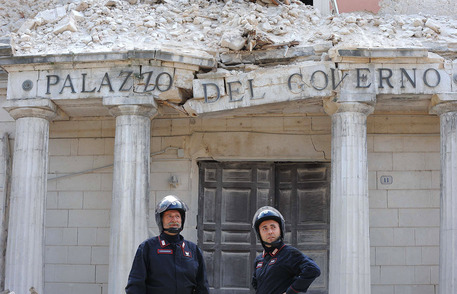Due carabinieri davanti al palazzo della prefettura dell'Aquila distrutto dal terremoto © ANSA