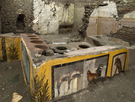 Il bancone ad elle del termopolio con i fianchi dipinti. Foto Parco Pompei, Luigi Spina © ANSA