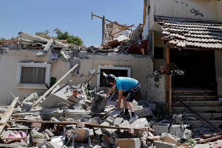 Un uomo fra le rovine della sua casa a Yehud, in Israele © AFP