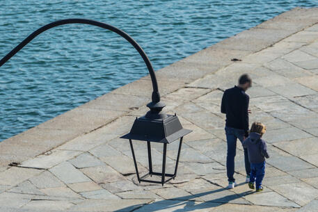 Un papà a passeggio con il figlio © ANSA