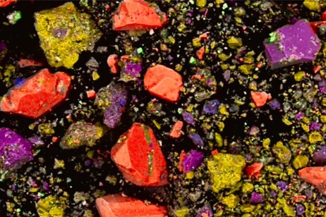 Immagine al microscopio, in falsi colori, della composizione del rossetto: ematite (rosso), cristalli di braunite (giallo), quarzo (rosa). Le particelle più piccole e chiare sono cristalli di galena (fonte: Federico Zorzi)