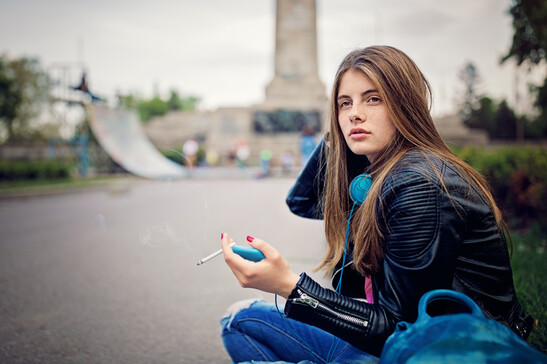 Una adolescente sola fuma una sigaretta foto iStock.