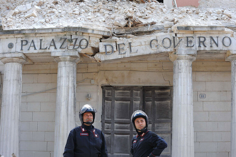 Due carabinieri davanti al palazzo della prefettura dell 'Aquila distrutto dal terremoto - RIPRODUZIONE RISERVATA